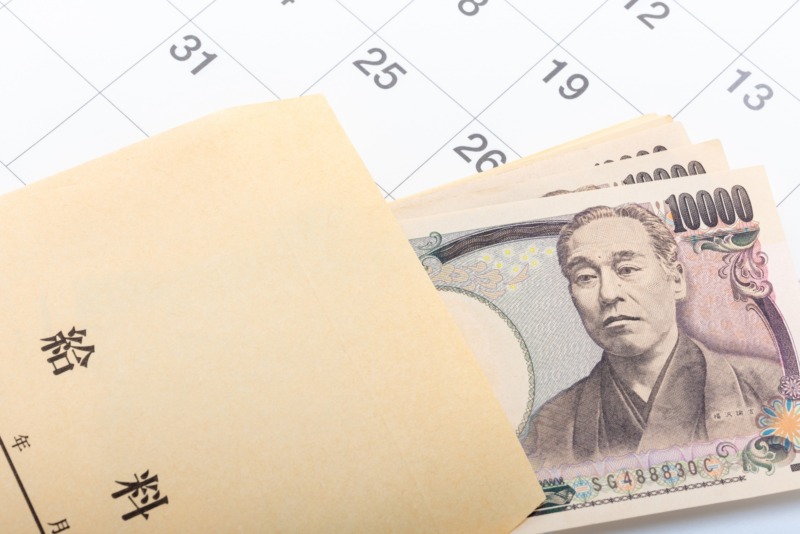 カレンダーと給料袋から覗く一万円札